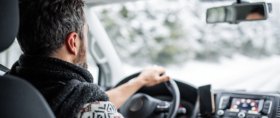 Homme conduisant une voiture en hiver